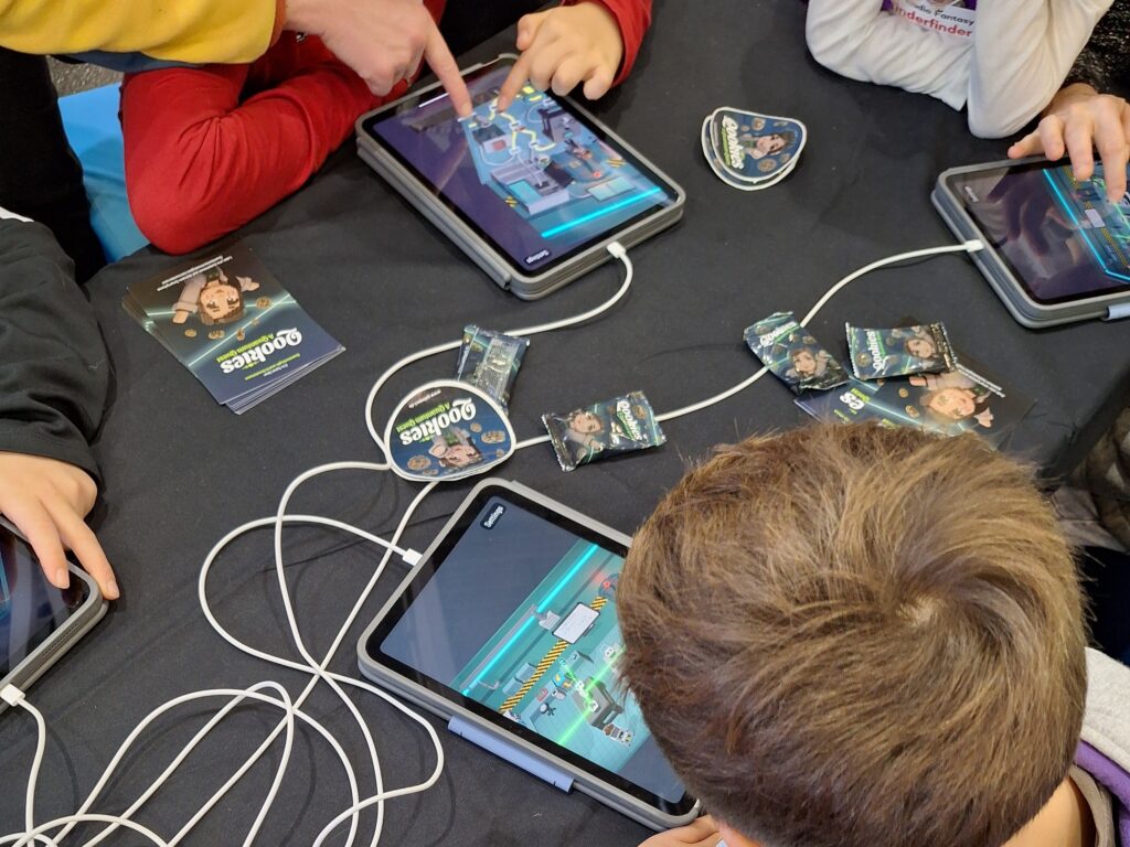 Kinder spielen Qookies auf der Spielwiesn in Augsburg, während sie Laser umlenken und Quanten-Schalter bedienen.