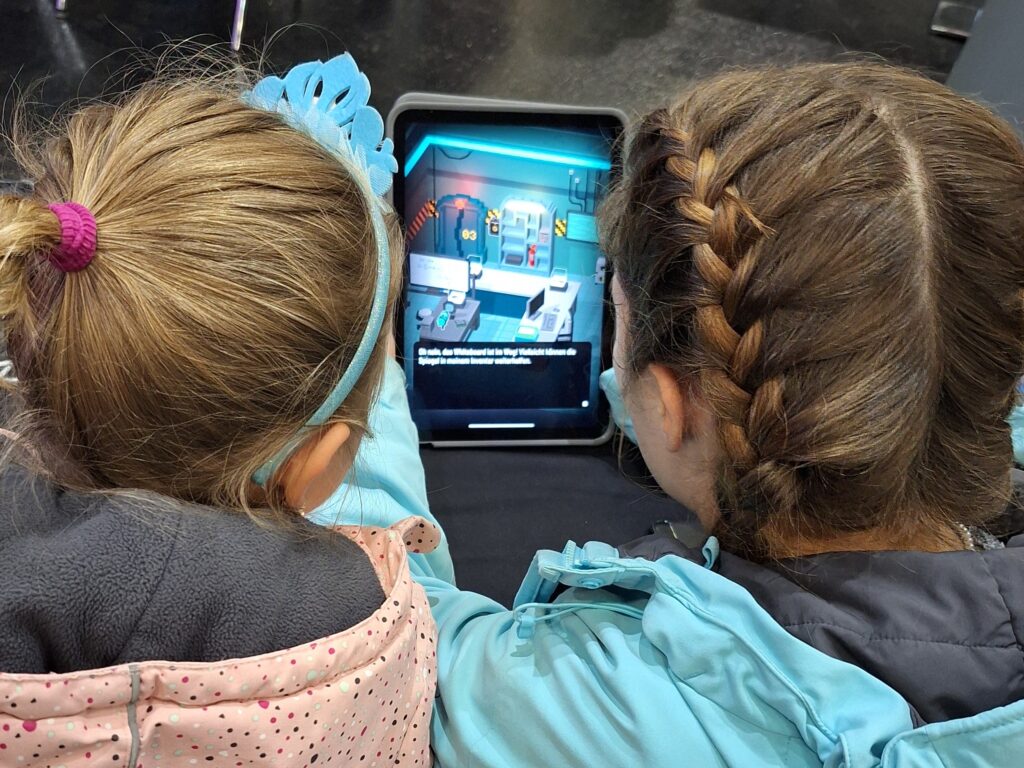 Zwei Mädchen spielen zusammen das Spiel Qookies auf der Spielwiesn in Augsburg.
